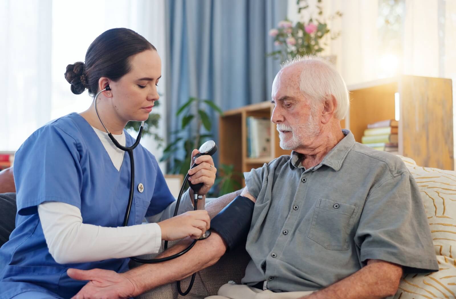 A skilled nurse of an assisted living community takes the blood pressure of a resident after surgery.